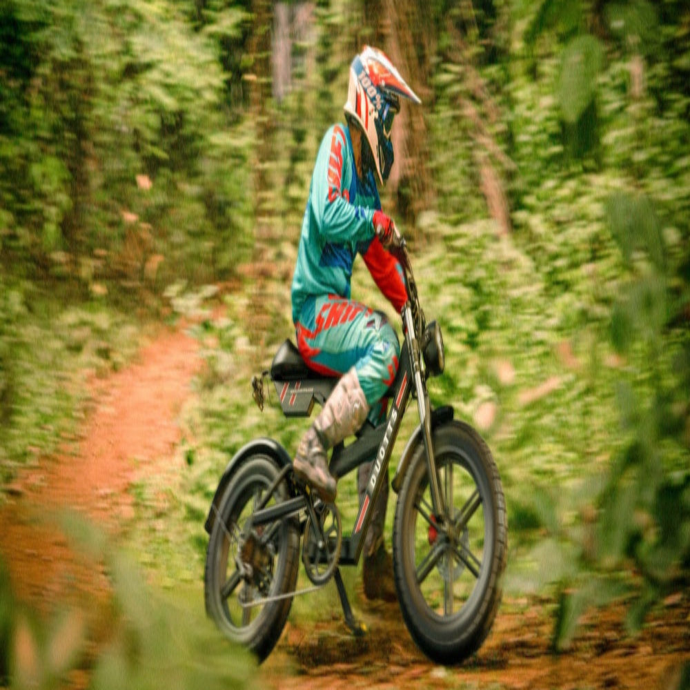 Person riding a motorcycle on a forest path