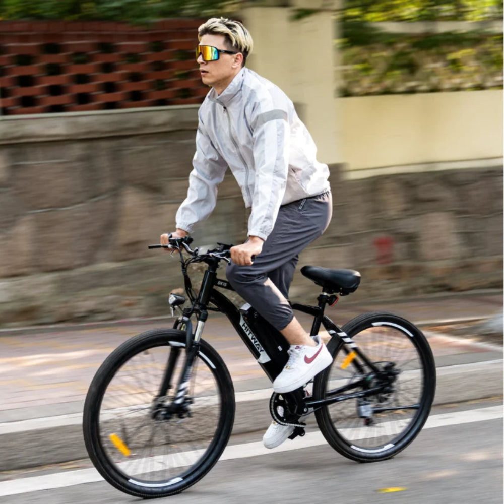 Person riding a black electric bike on a road with a blurred background