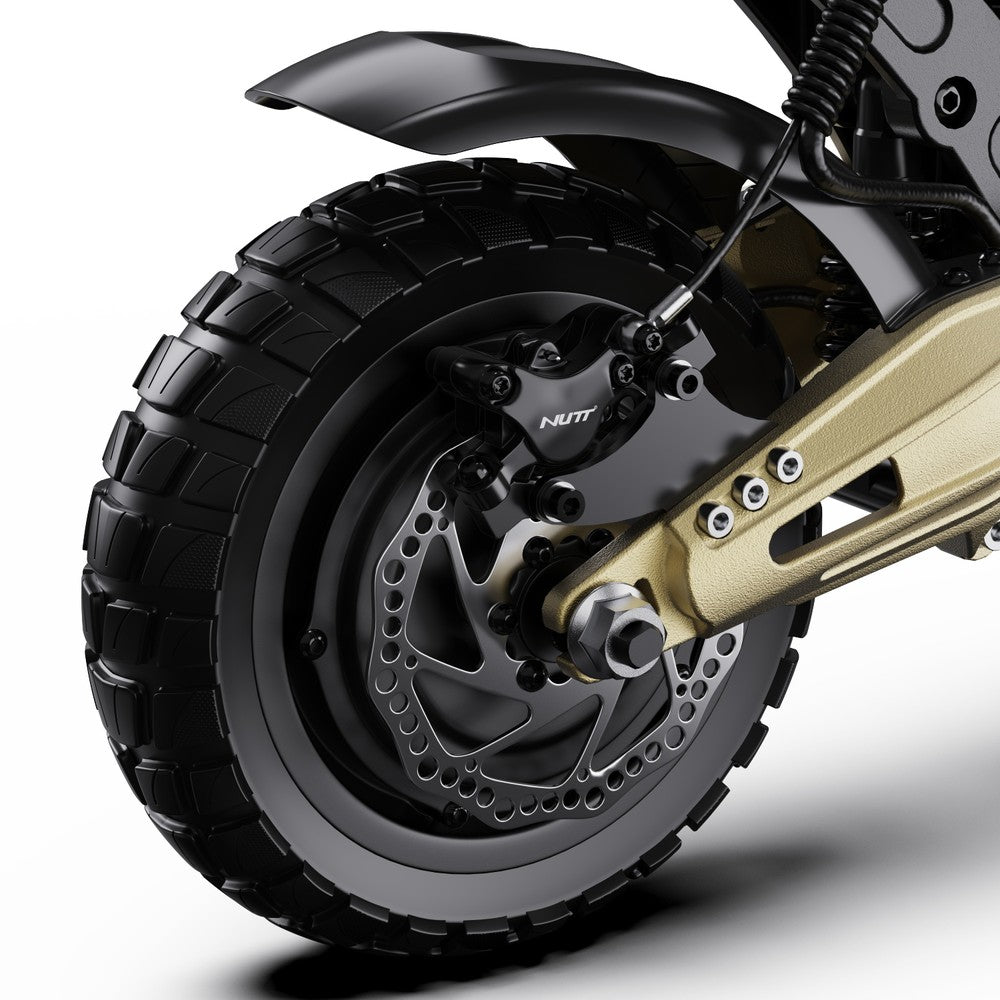 Close-up of a motorcycle wheel with black tire and gold suspension on a white background