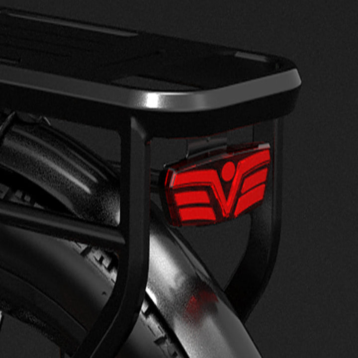 Close-up of a black vehicle bumper with a red logo on a dark background