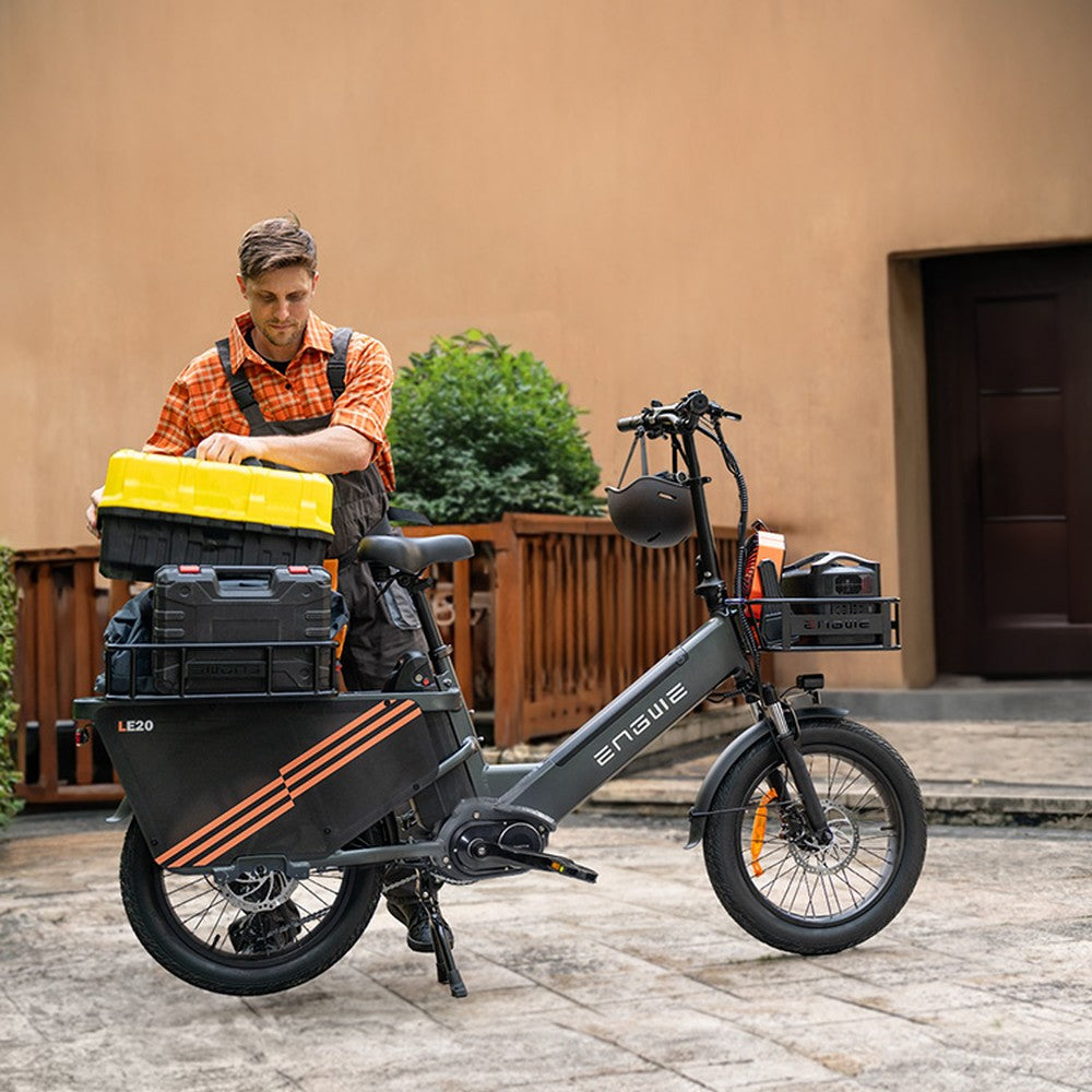 Man with a cargo bike loaded with tools in an outdoor setting