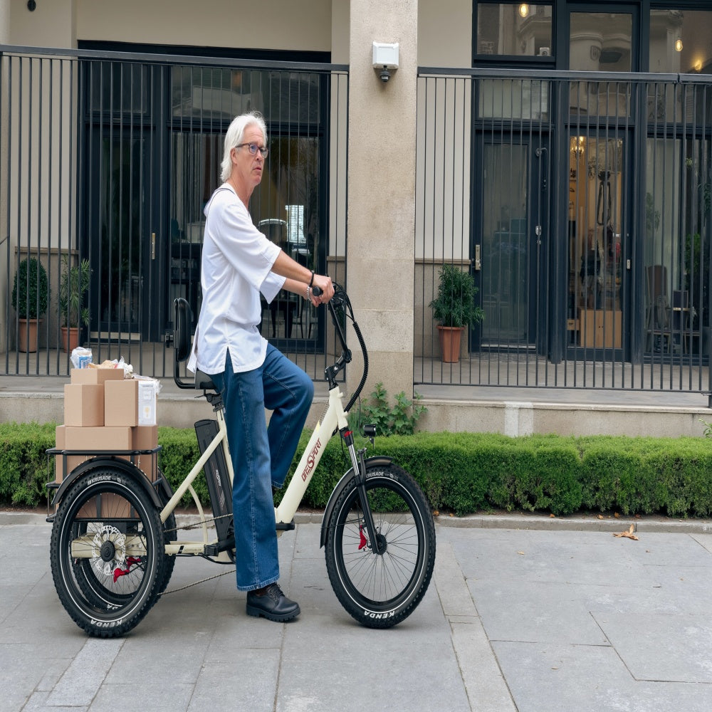 Person riding a cargo bike with boxes on a sidewalk