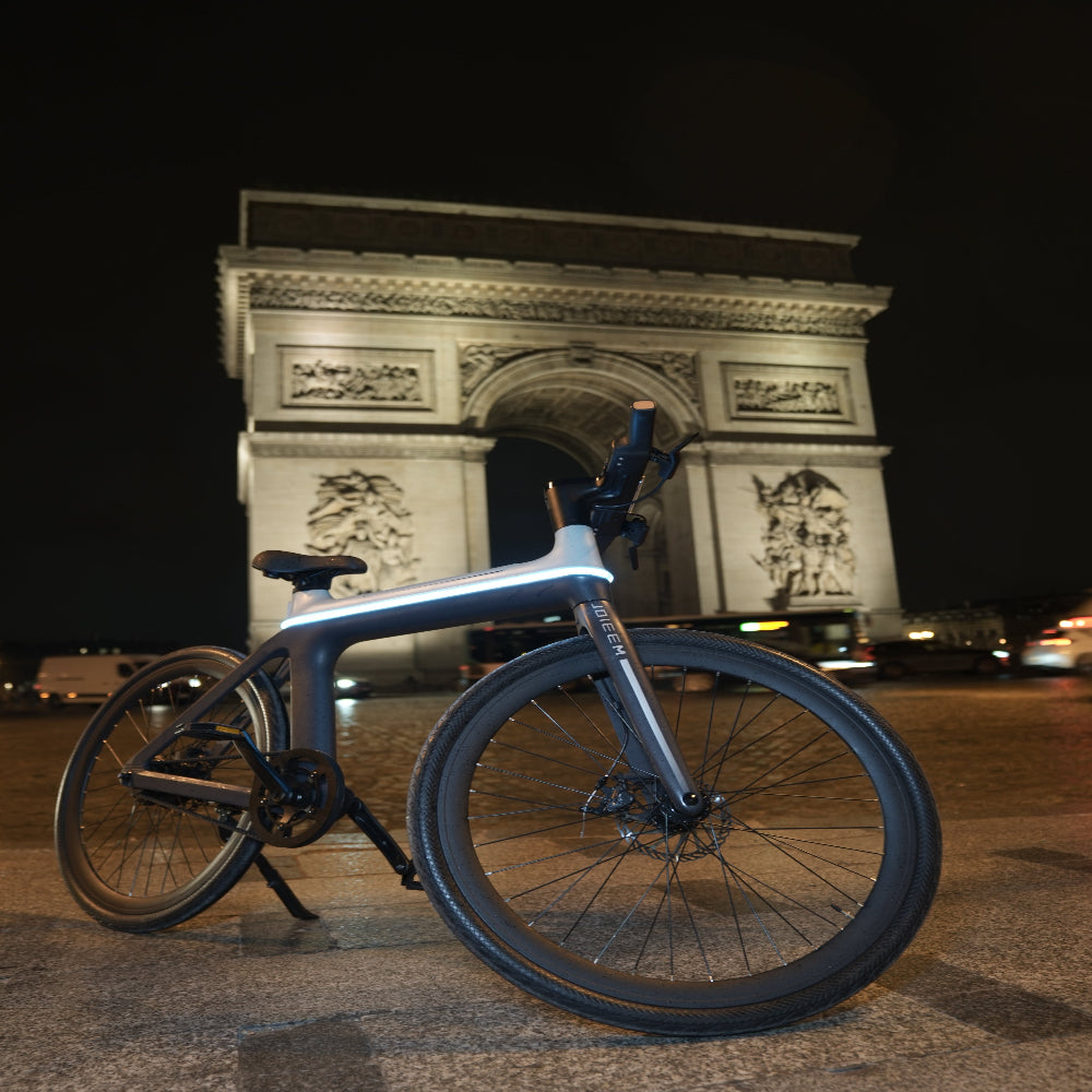 Bicycle leaning against a wall with a nighttime cityscape background