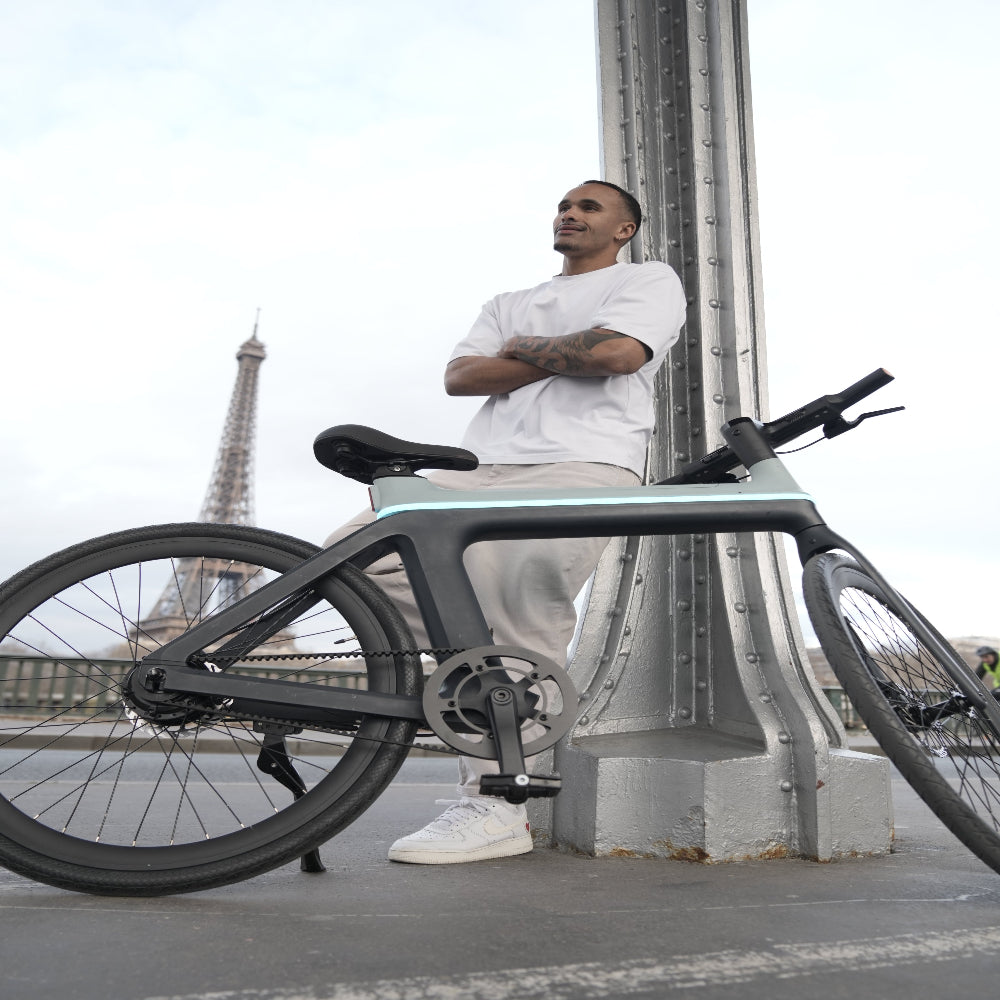 Man sitting on a modern bicycle with the Eiffel Tower in the background