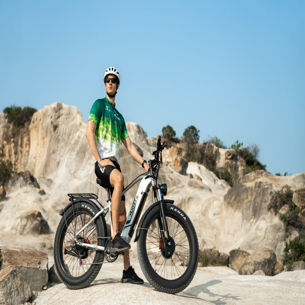 Person with an electric bike in a rocky outdoor setting