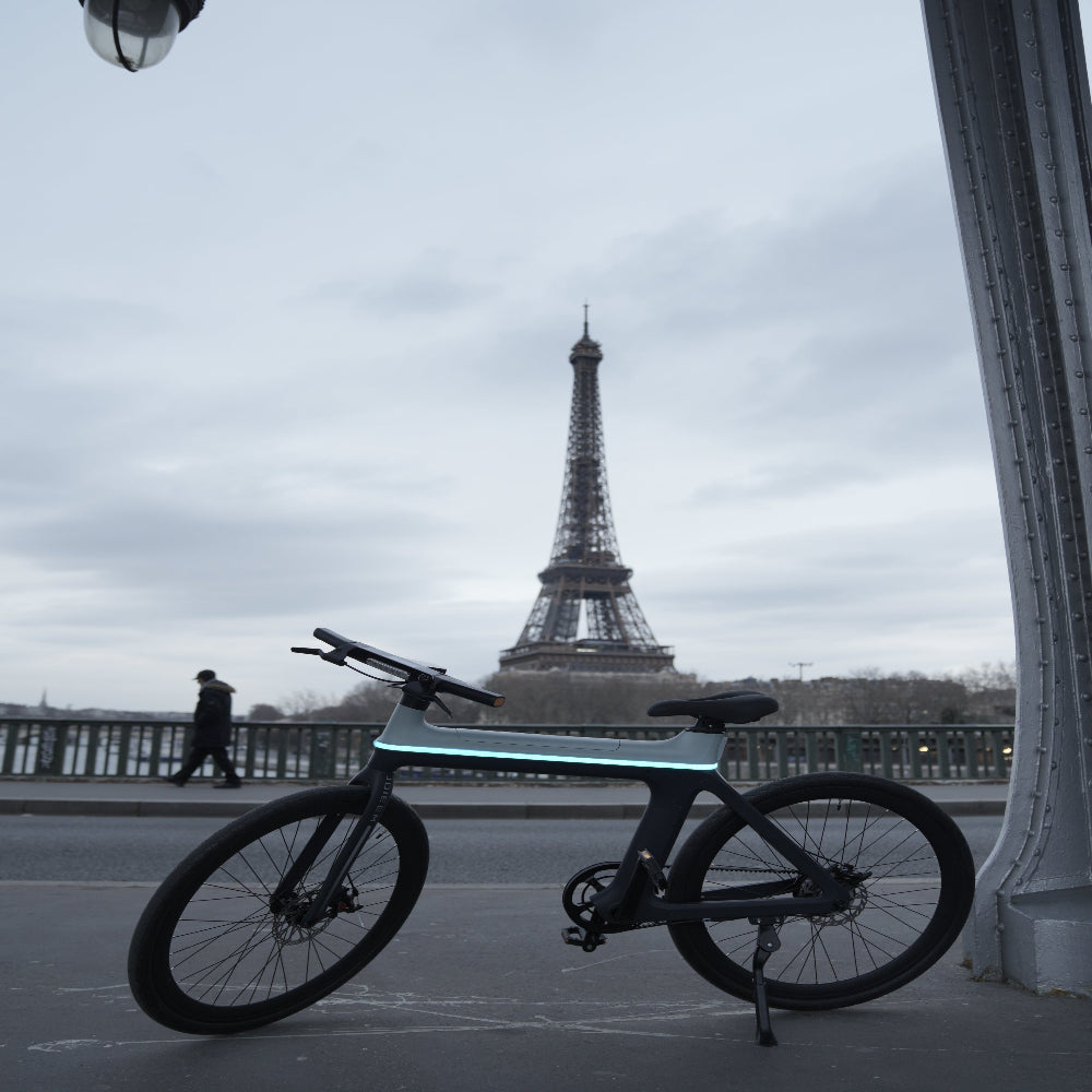 Bicycle leaning against a wall with the Eiffel Tower in the background