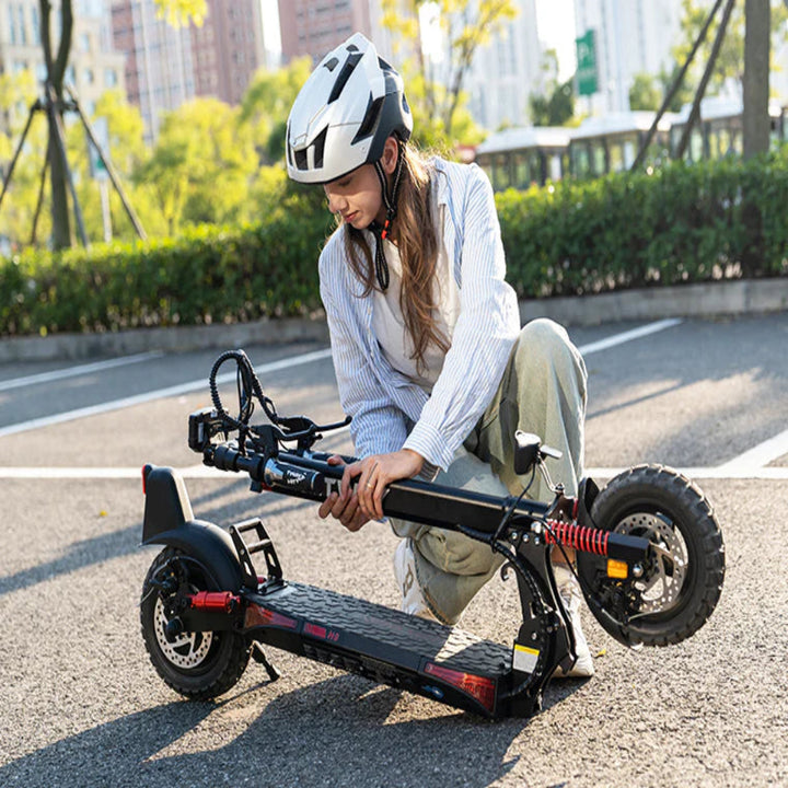 Person adjusting an electric scooter on a city street