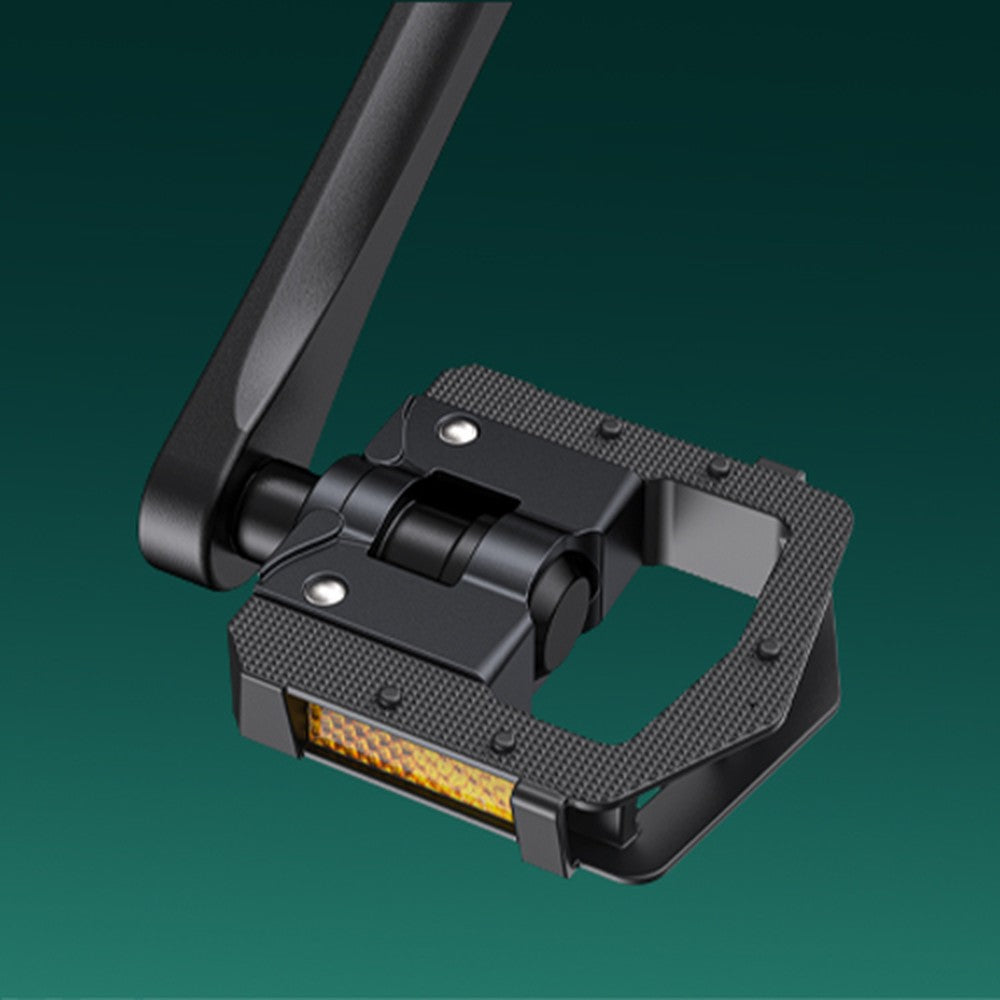 Black metal pedal with yellow light on a green background