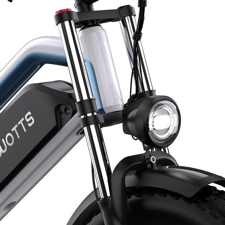 Close-up of a scooter's front suspension fork and headlight with 'DUOTTS' branding.