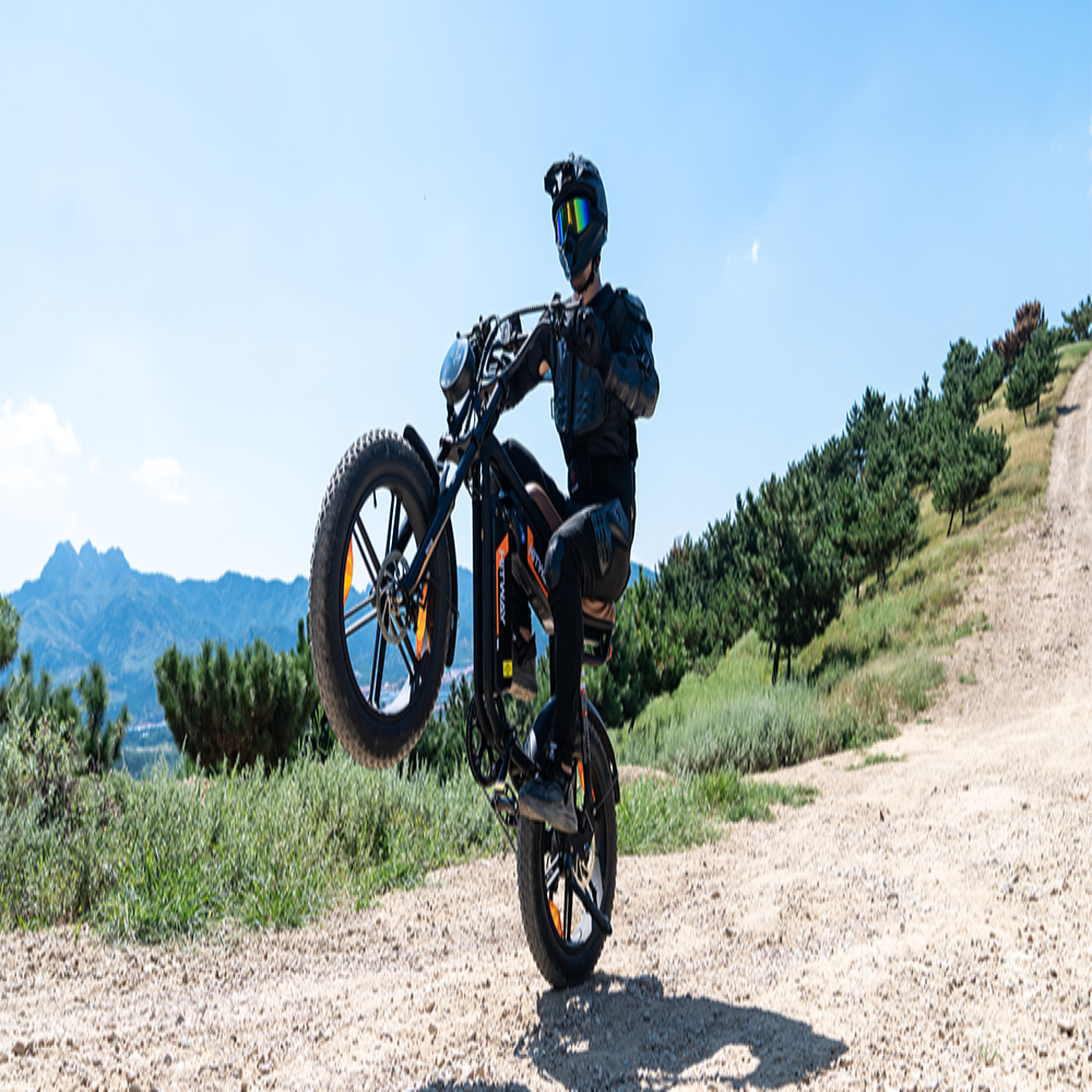 Person riding a motorcycle on a dirt road with mountains in the background
