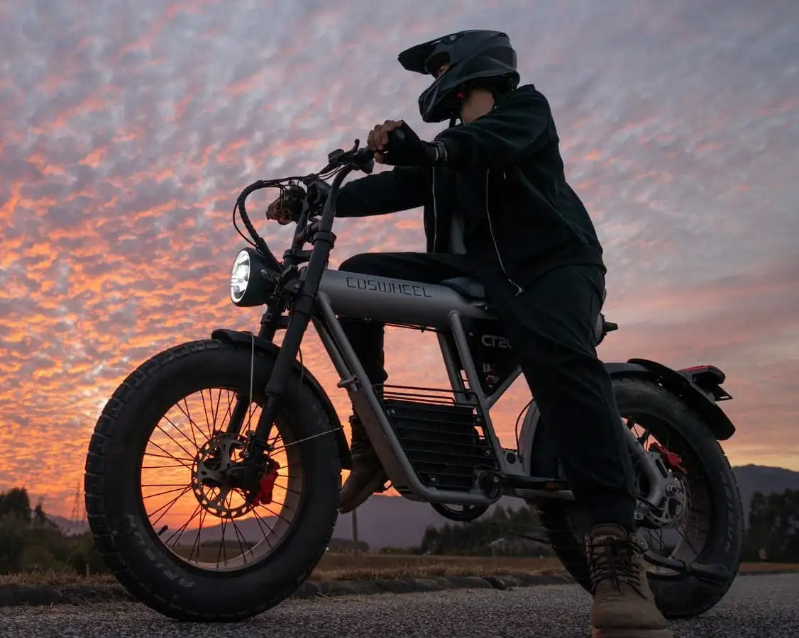 Person on a motorcycle against a sunset sky