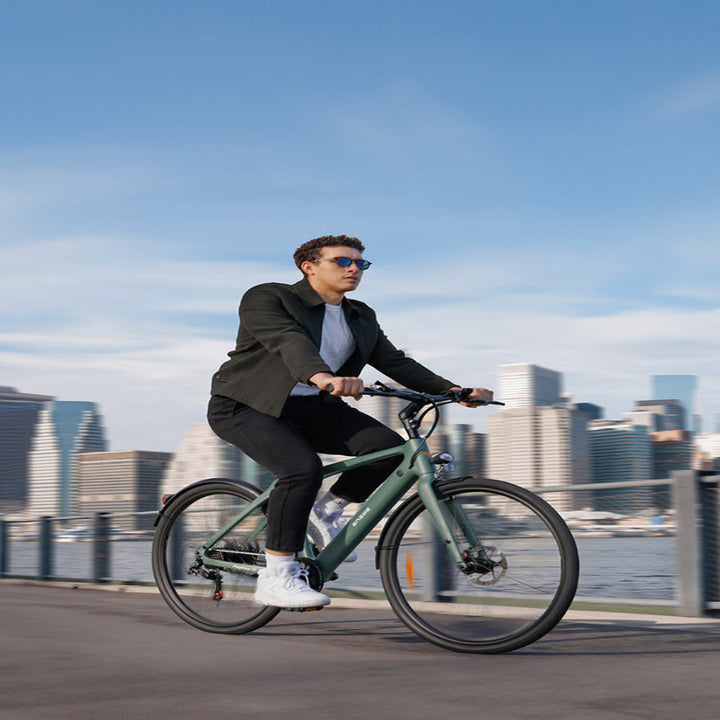 Man riding a bicycle with a city skyline in the background