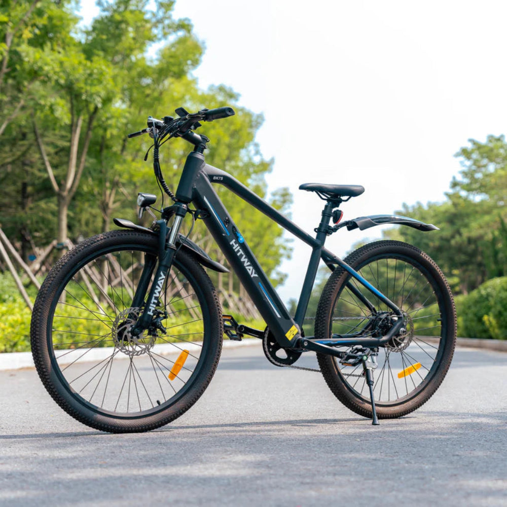 Black electric bicycle on a road with greenery in the background