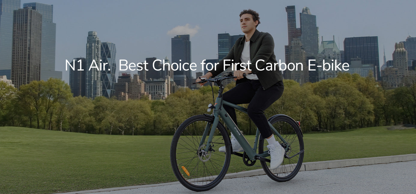 Persoon rijdt op een fiets met een stadsgezicht op de achtergrond, ter promotie van de N1 Air carbon e-bike.
