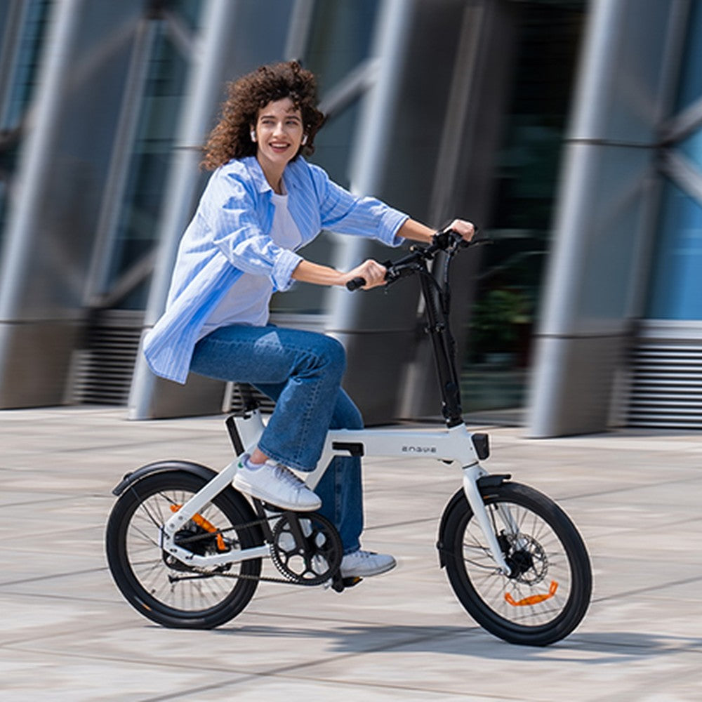 Persoon rijdt op een witte elektrische fiets in een stedelijke omgeving